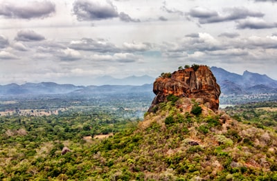 brown rock formation beside green trees at daytime sri lanka zoom background