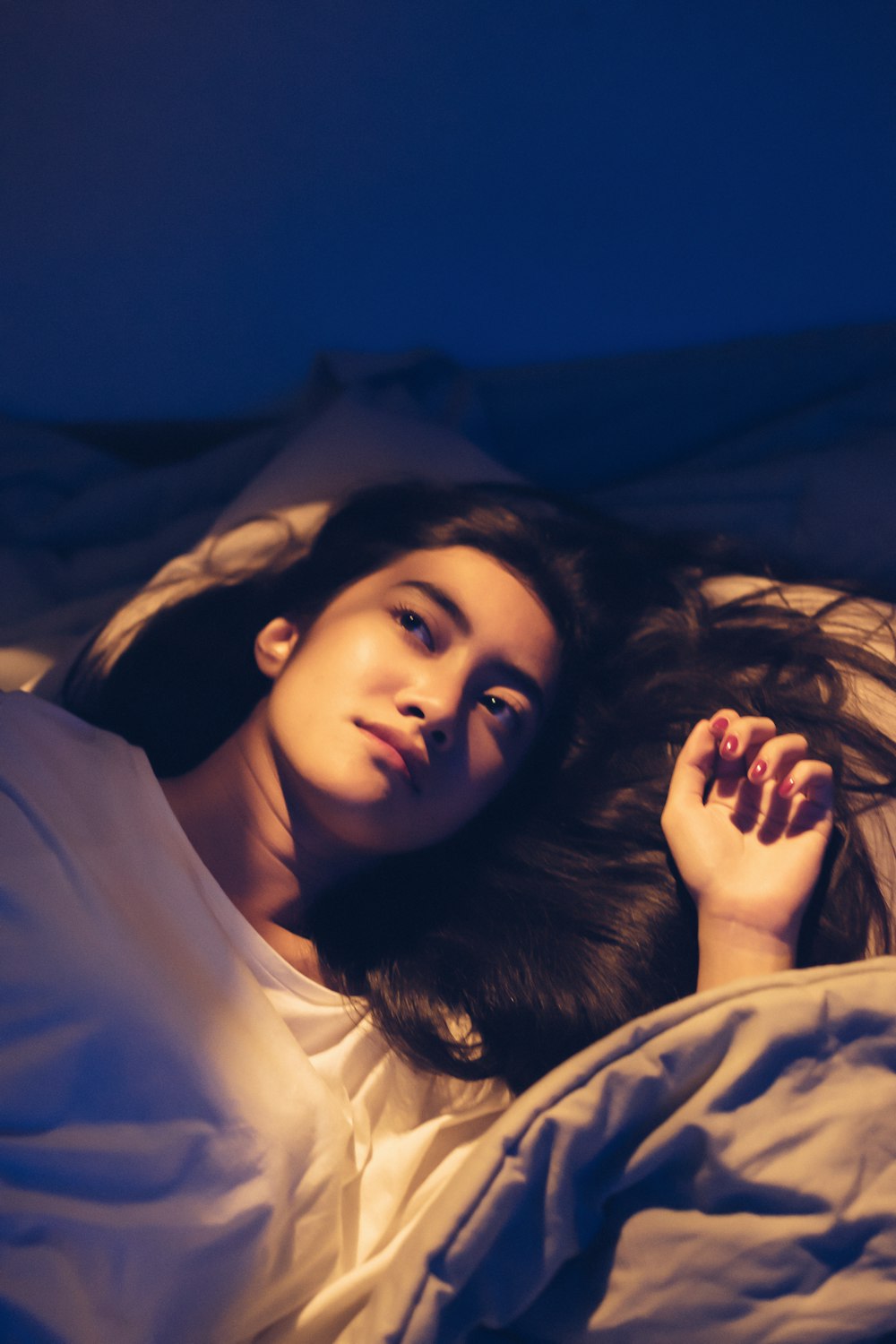 woman lying on bed while looking up