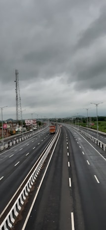 A close-up of a truck driver communicating with dispatch via headset, with a highway stretching ahead in the background.