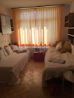 A cozy room featuring twin beds, warm lighting, and a charming decor for a comfortable stay.