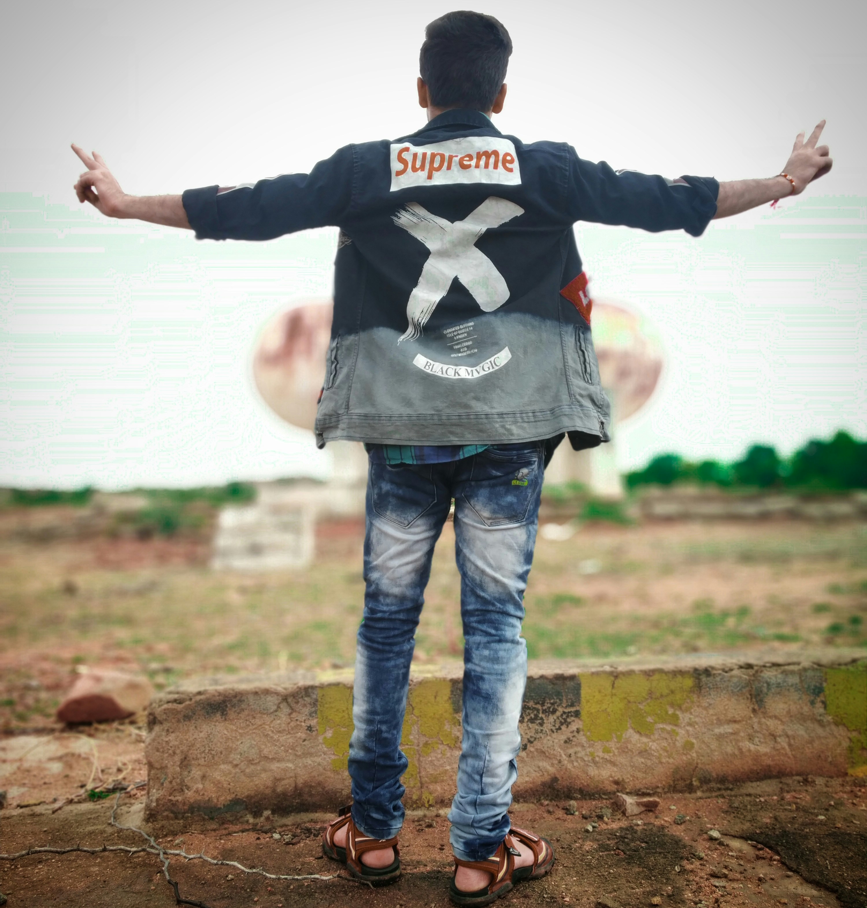 a man standing on a dirt ground with his arms outstretched