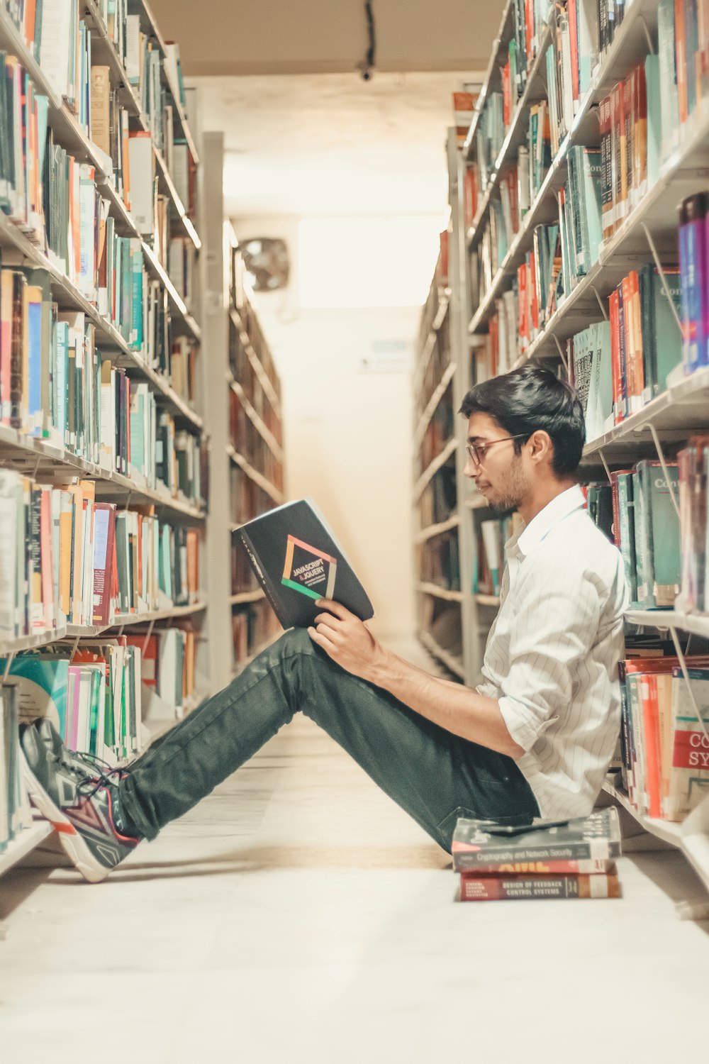 Mann liest Buch in der Bibliothek