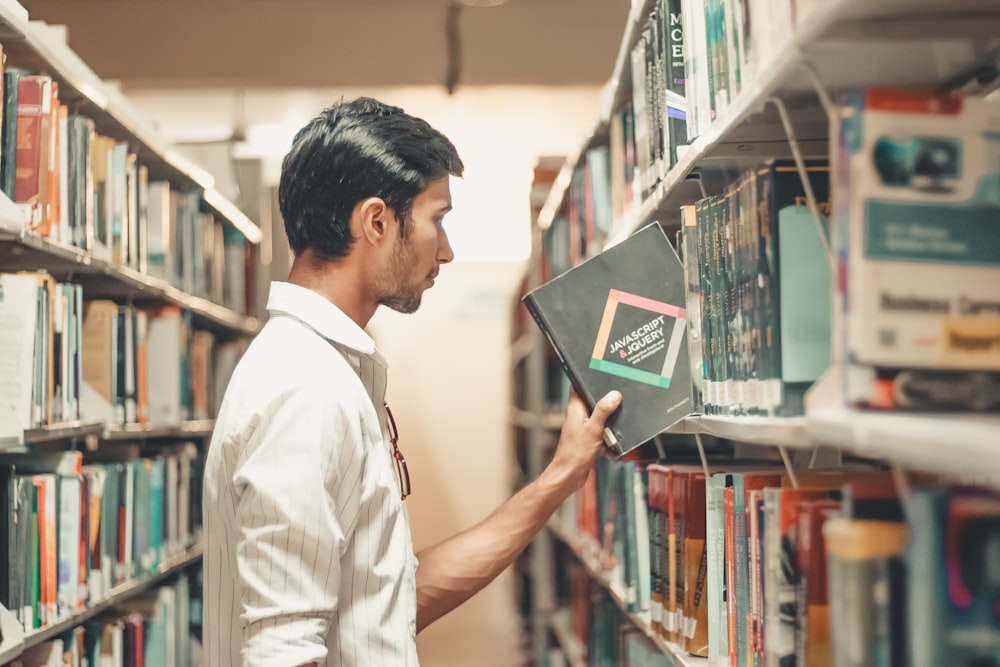 man holding black reading book