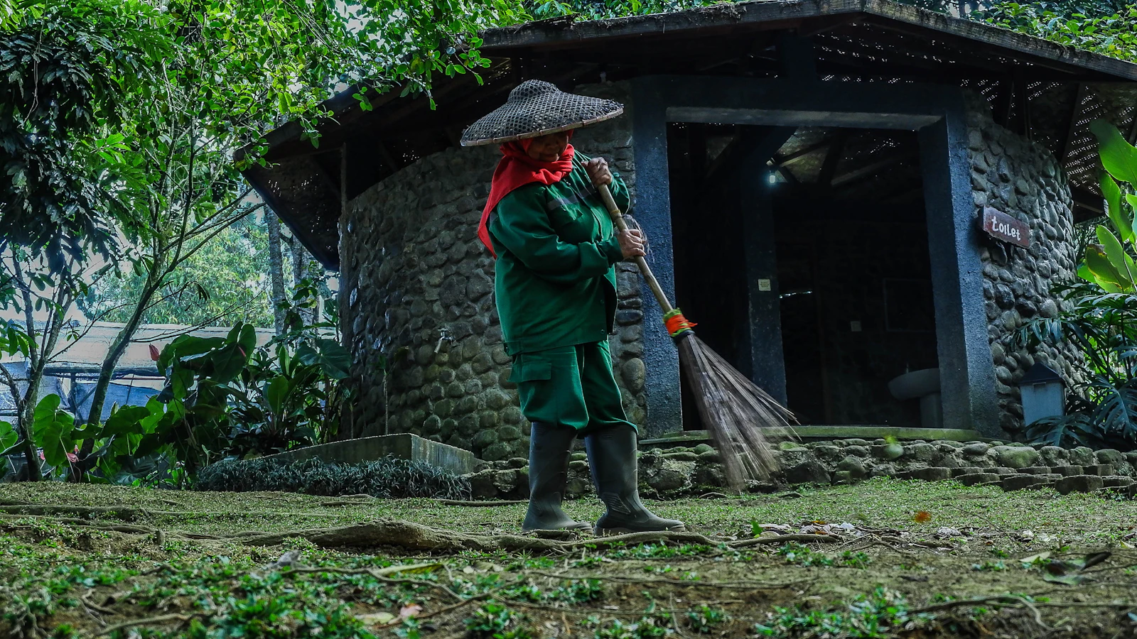 Pekerja menyapu dan merawat halaman rumah