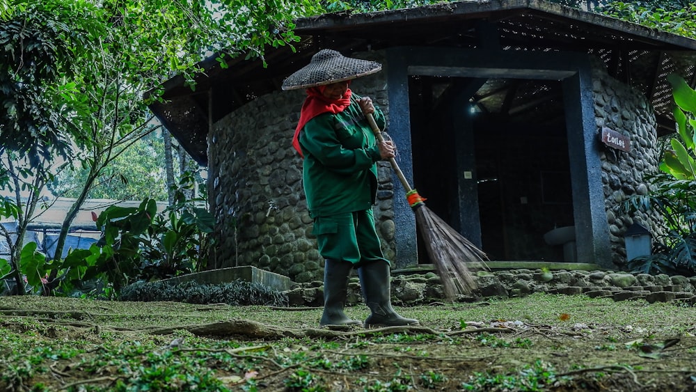 person about to swipe broom on grass field