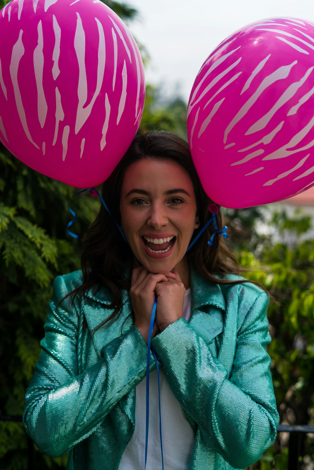 woman holds two pink balloons