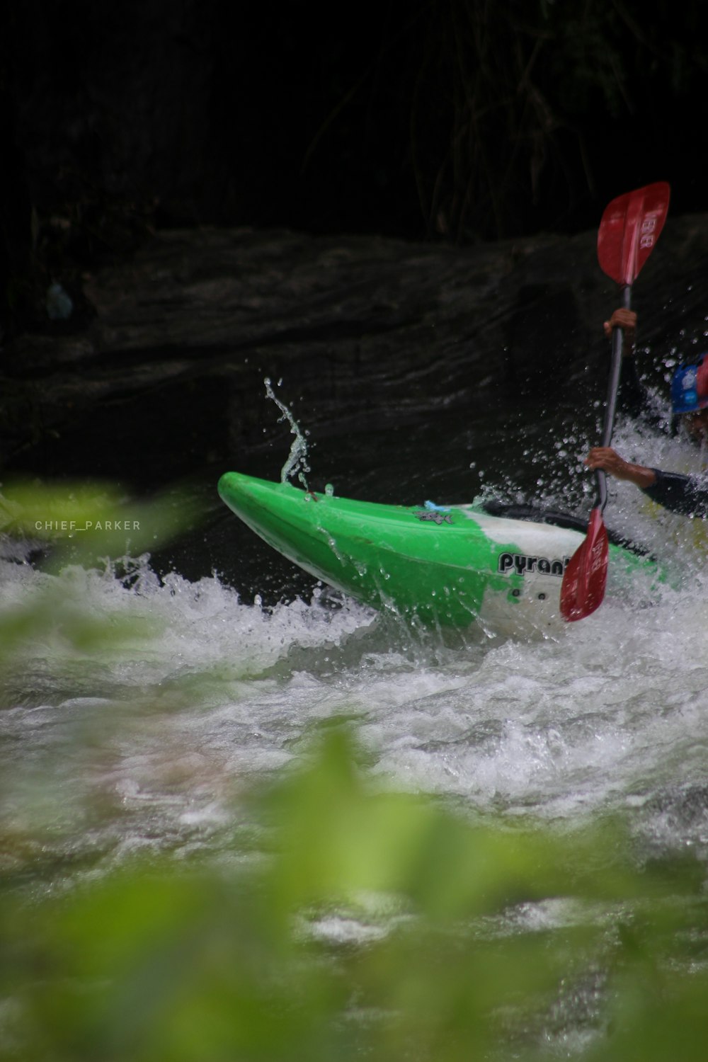 person on green and white kayak