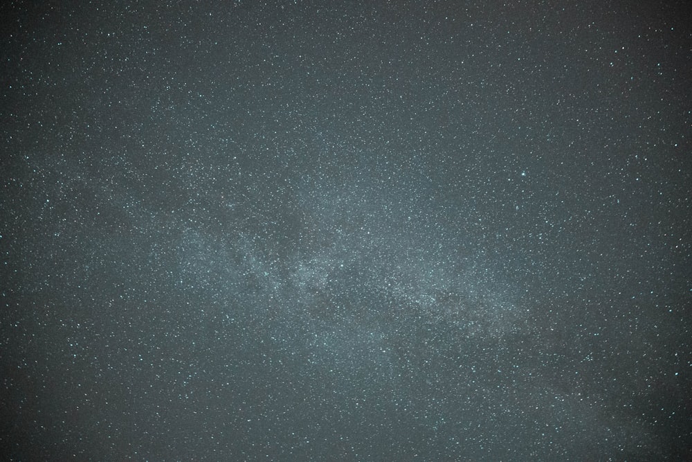 a dark sky with stars and a few clouds