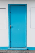 Close-up of a freshly painted white door with smooth blue trim.