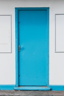 Close-up of a freshly painted white door with smooth blue trim.