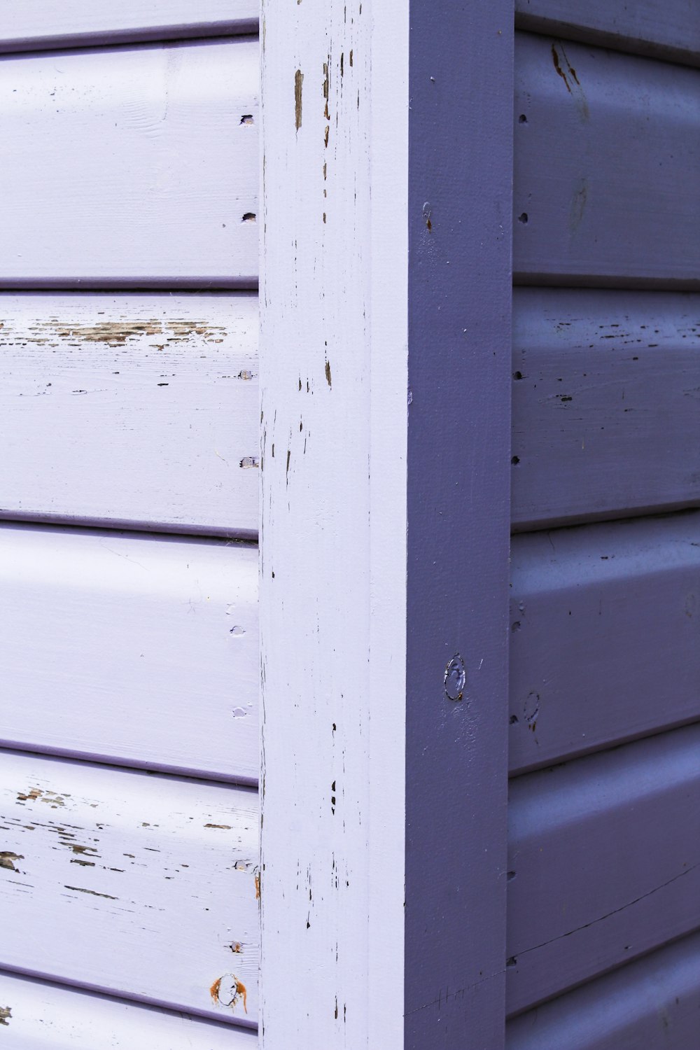 a close up of the side of a building with peeling paint