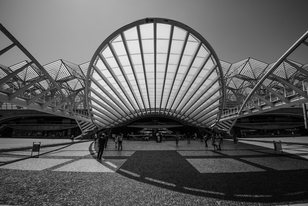 grayscale photography of people gathering beside building