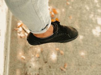 person in gray jeans and black low top sneaker