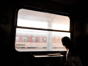woman standing beside window panel