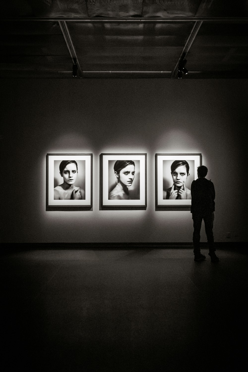 man looking at portraits