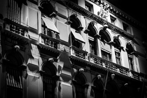 Black-and-white photo of a historic building facade with deep red architectural details.
