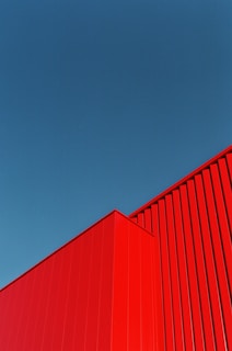 a red building with a blue sky in the background