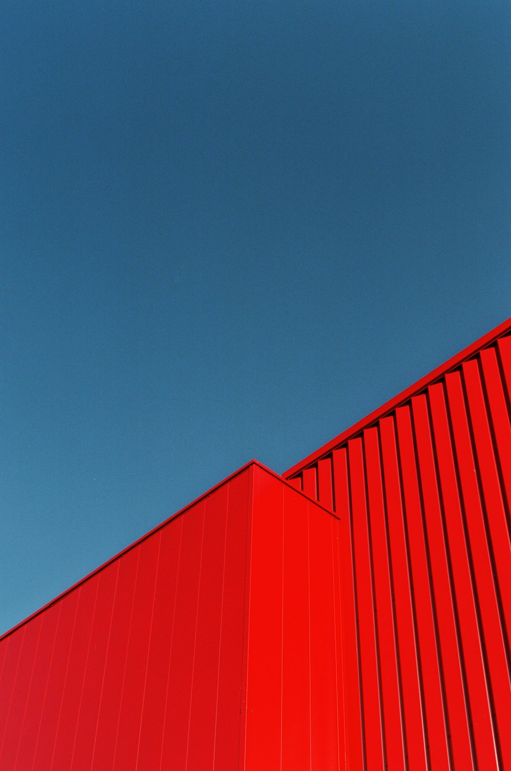 Un edificio rosso con un cielo blu sullo sfondo