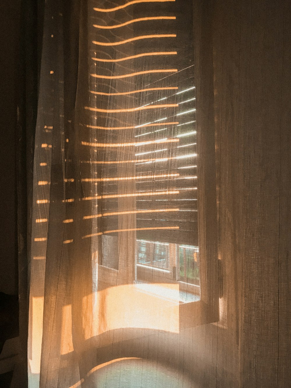 a close up of a window with sheer curtains