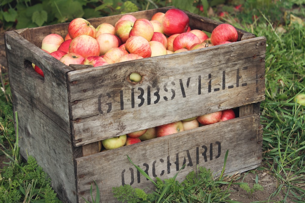 a wooden crate filled with lots of apples