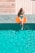 woman lying beside swimming pool during daytime