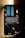 A smartphone leaning against a wall displays a message about conserving energy by turning off unused power points and lights. The screen background features hanging light bulbs, some lit and others dim, casting a warm glow against a dark and possibly urban skyline.