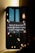 A smartphone leaning against a wall displays a message about conserving energy by turning off unused power points and lights. The screen background features hanging light bulbs, some lit and others dim, casting a warm glow against a dark and possibly urban skyline.