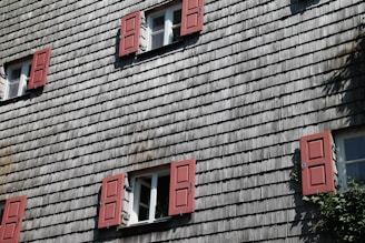 A charming house facade showcasing a variety of large sliding windows in sunlight.