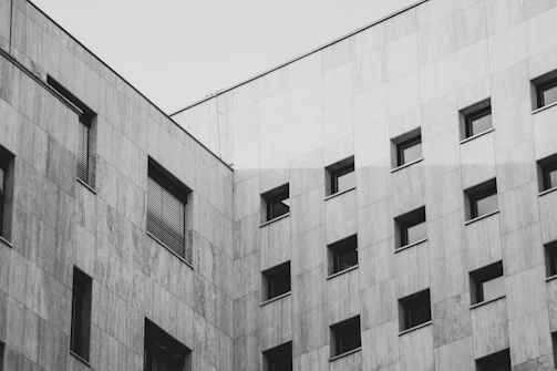 Monochrome exterior shot of a modern architectural facade with geometric shapes.