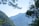 A serene mountain view with lush greenery and soft clouds.