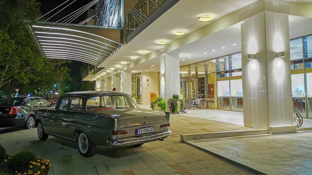 gray sedan parked beside lighted building