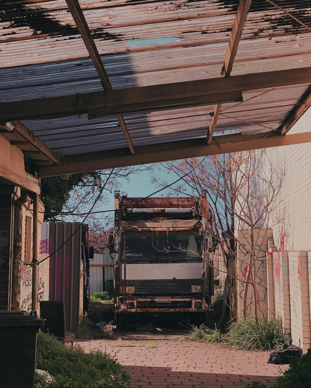 wrecked white vehicle on garage at daytime