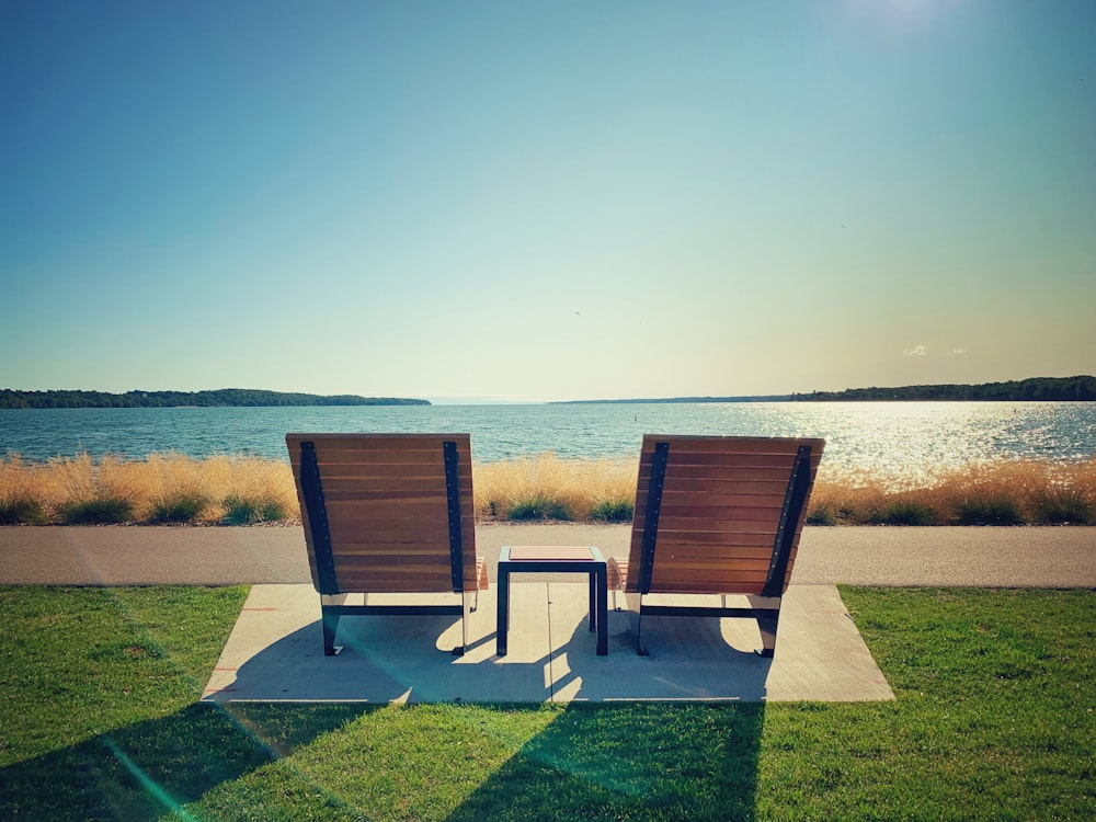 a couple of lawn chairs sitting on top of a lush green field