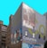 A building facade features large murals, including an abstract art piece with vivid colors and a black-and-white image of a landscape and a tornado. The words 'Columbia College Chicago' are prominently displayed against a solid backdrop.