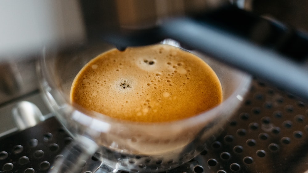 a cup of coffee sitting on top of a coffee maker