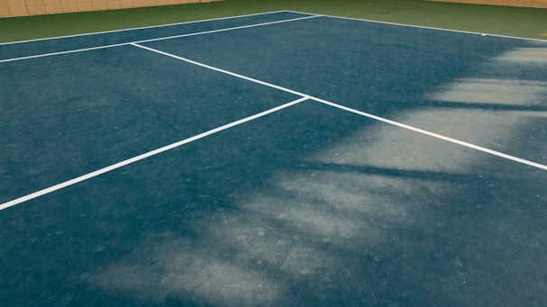 A tennis ball court with blue flooring