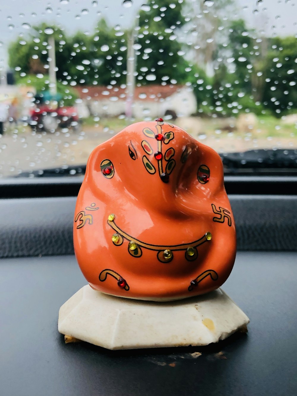 a ceramic animal sitting on top of a car dashboard