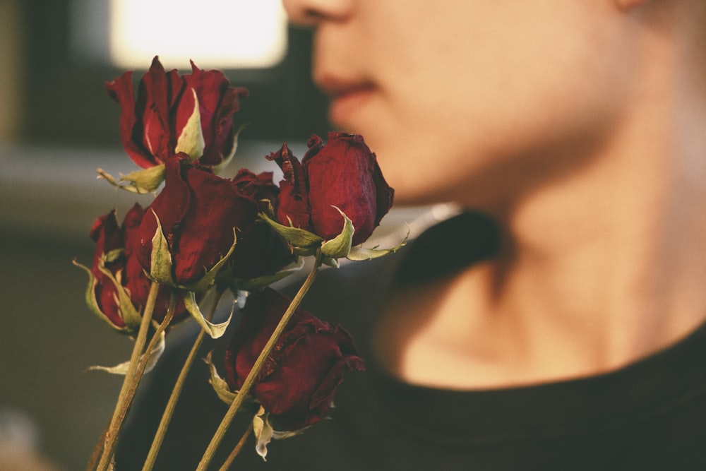 a close up of a person holding a bunch of roses