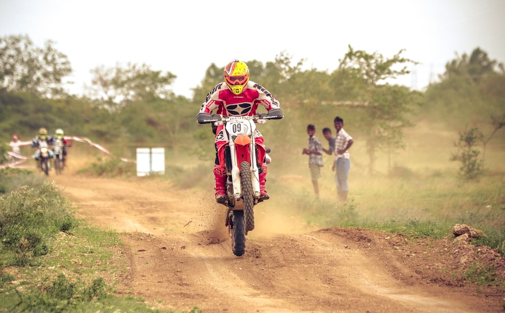 man riding on dirt bike racing on dirt road