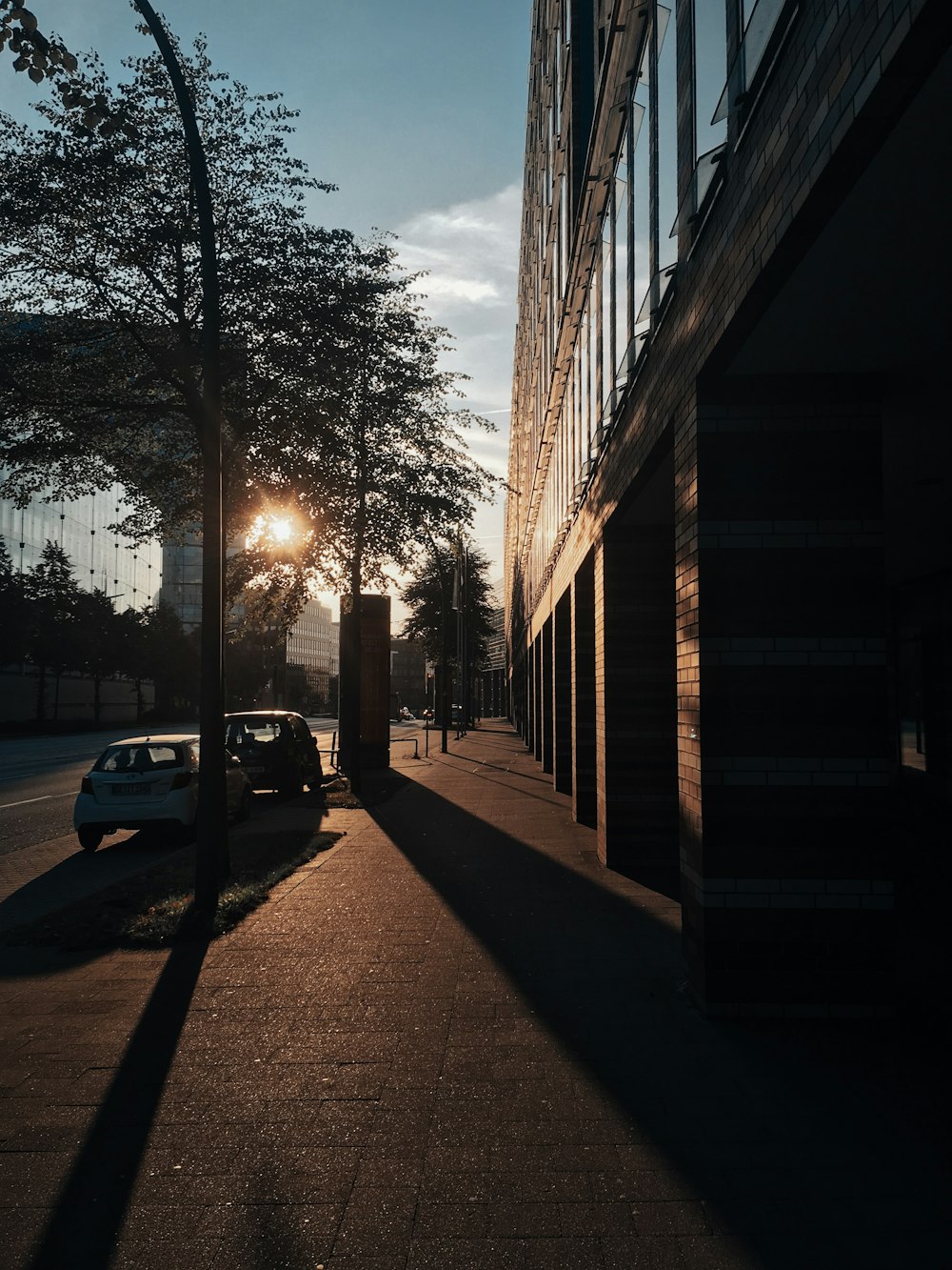 a car parked on the side of a road next to a tall building