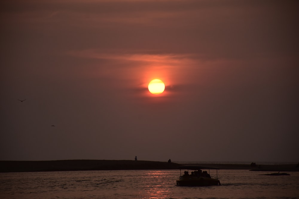 silhoette of boat on sea water during daytime