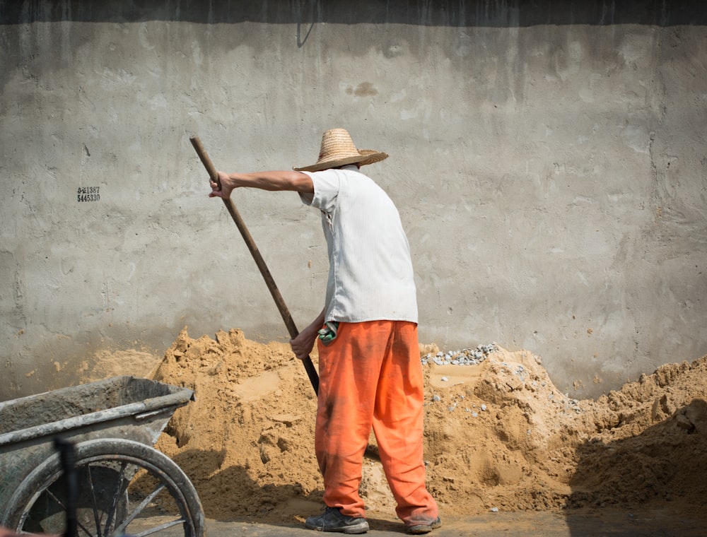 homme ratissant le sable