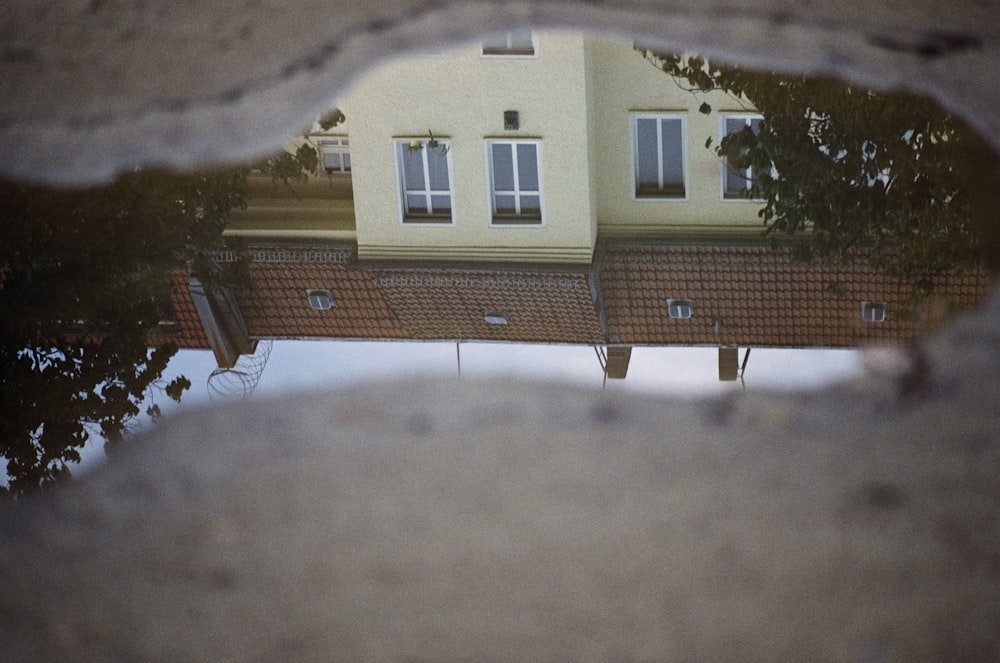 a reflection of a house in a puddle of water