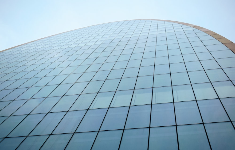low-angle photography of blue glass walled building
