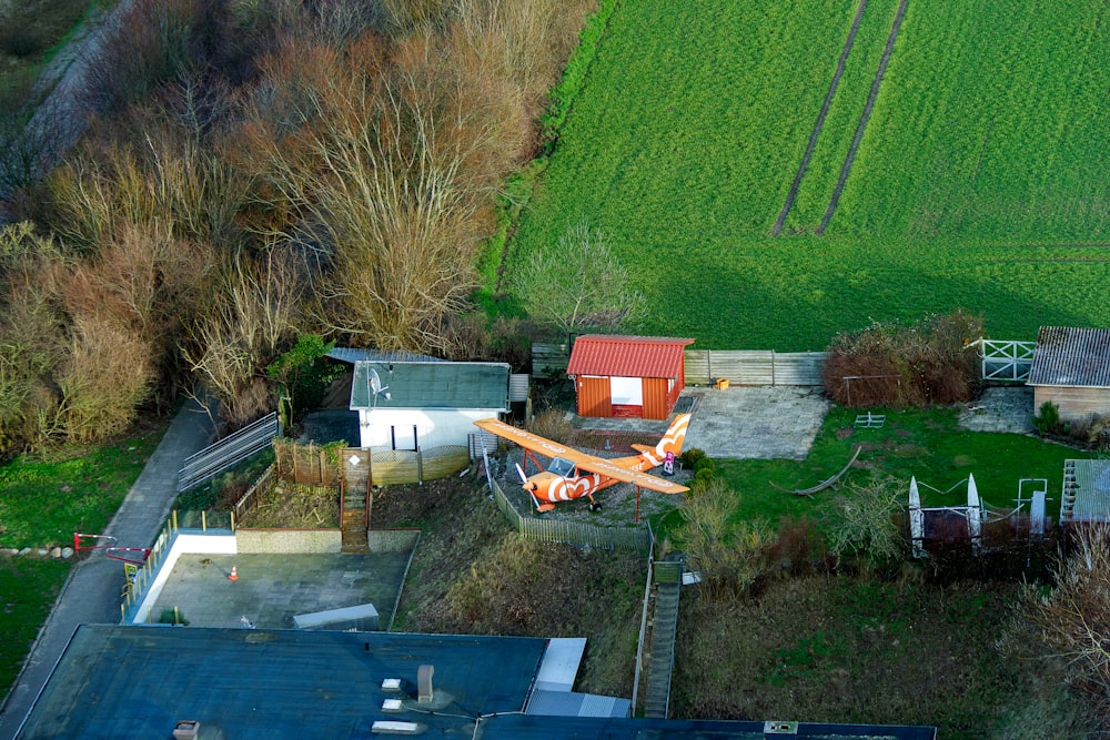 an aerial view of a farm with a plane in the foreground