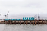 Loading dock with containers being unloaded under a cloudy sky.