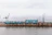 Photo of a busy industrial loading dock with trucks being loaded with coke under a steel-grey sky.