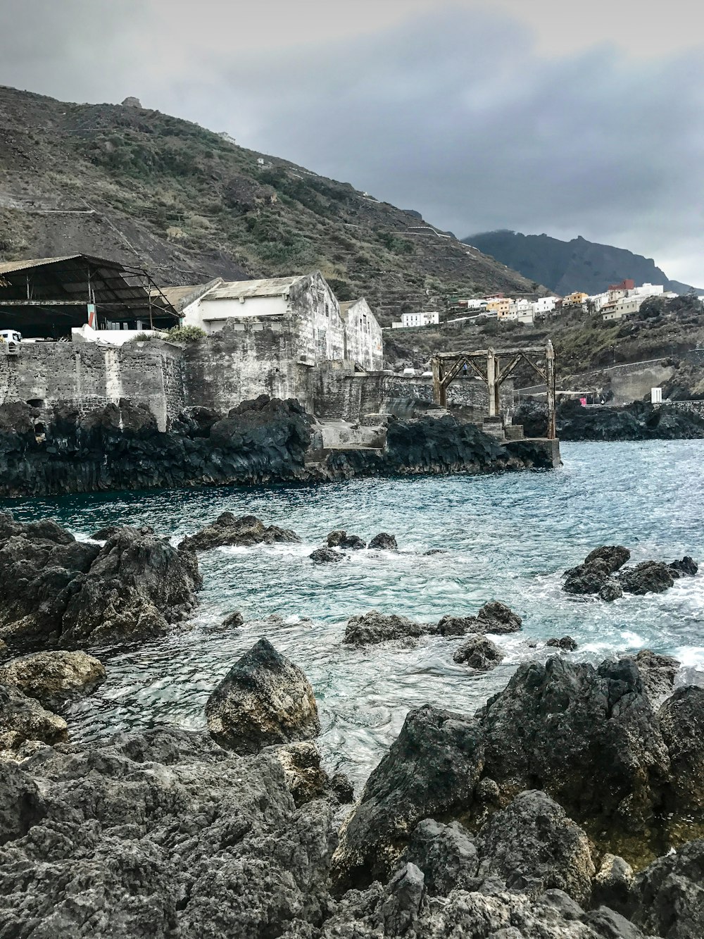 a large body of water next to a rocky shore