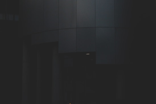 A sleek, dark obsidian architectural structure illuminated with subtle gold accents, embodying mysterious elegance and flow.