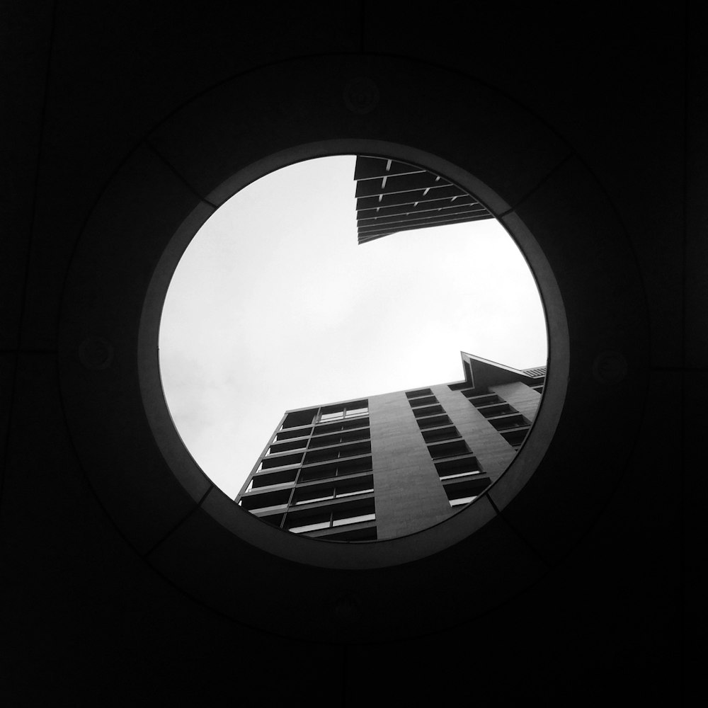 una finestra rotonda con vista su un grattacielo